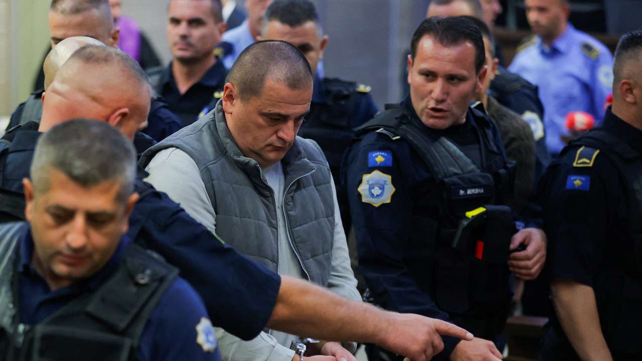 Kosovo police officers escort the alleged Serbian gunman Vladimir Tolic at the basic court in Pristina