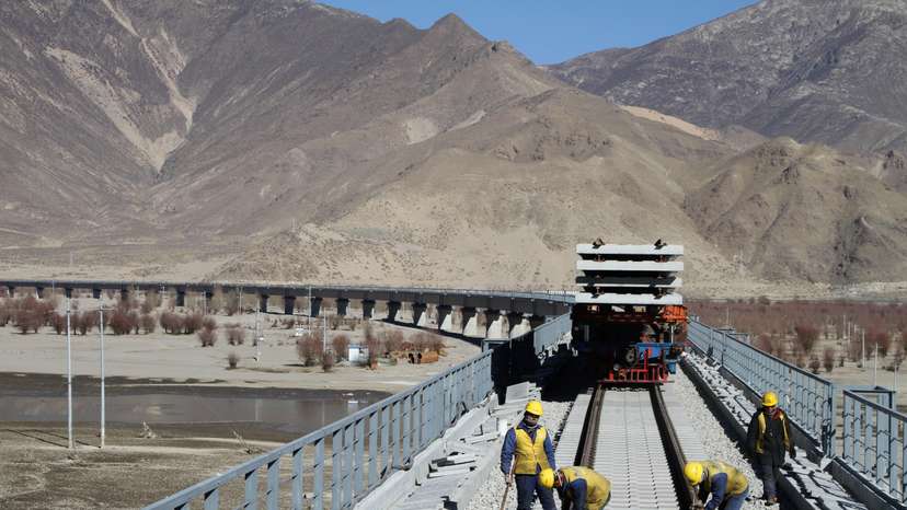 Workers are seen on railway tracks at a bridge over Yarlung Tsangpo river as they work on the construction of the railroad linking Lhasa and Nyingchi