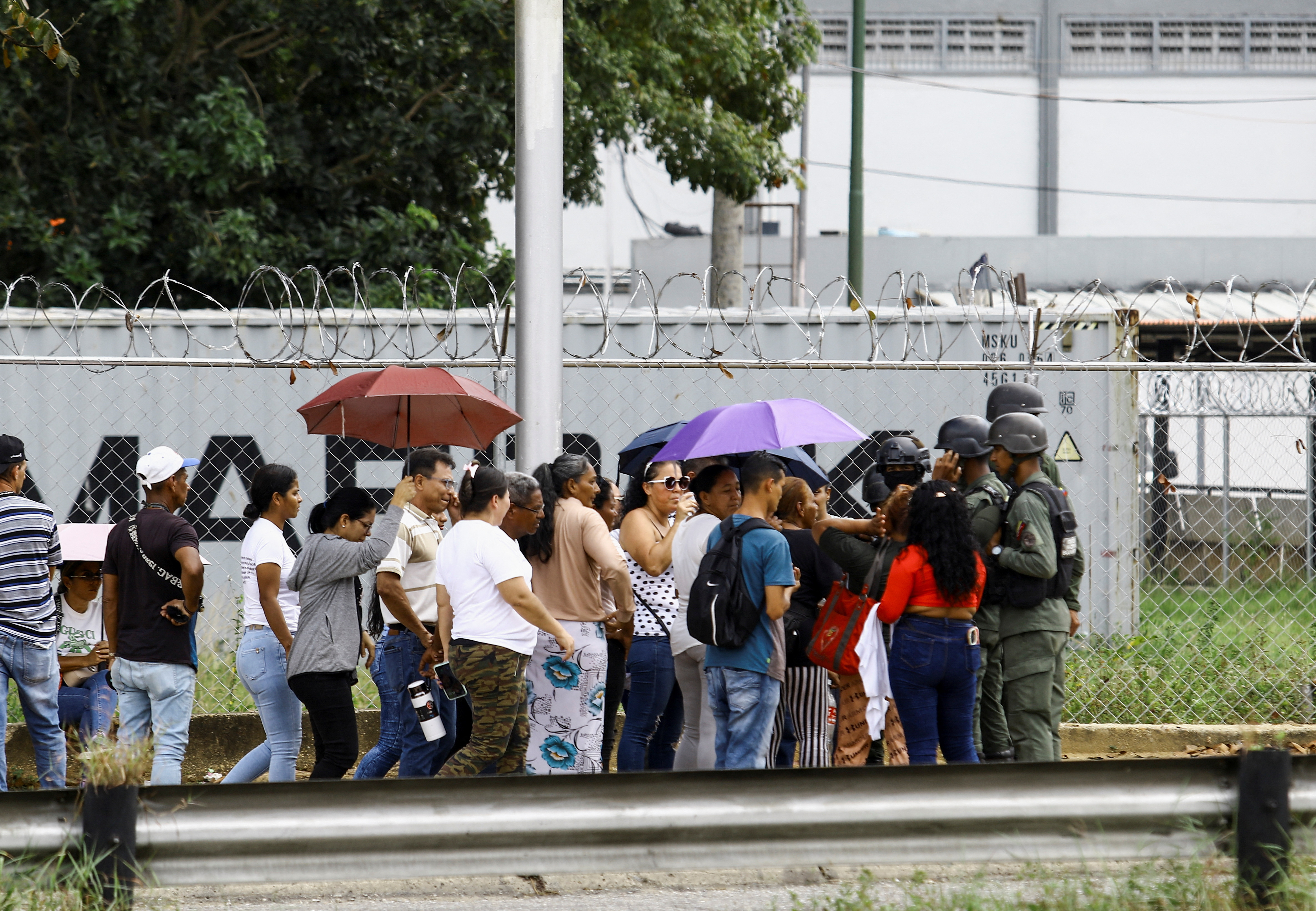 People wait outside the prison for the release of their loved ones detained during protests, in Tocuyito