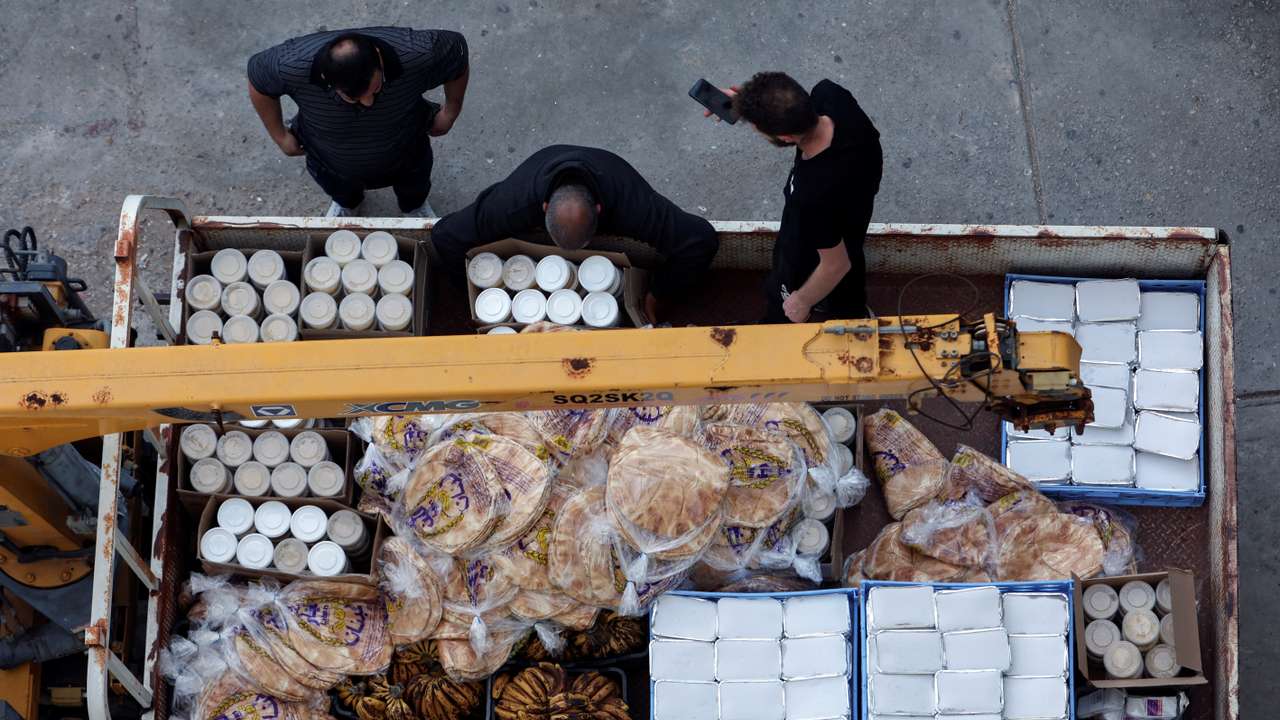 Volunteers prepare to distribute Iftar meals at a school turned into shelter, in Tyre