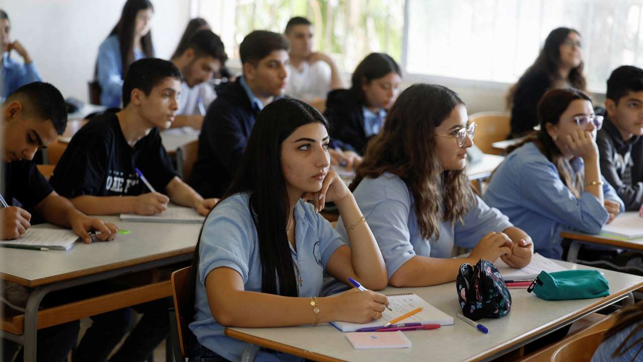 Lebanese students attend lessons at a public school, which is hosting displaced people in one of its buildings, in Amchit