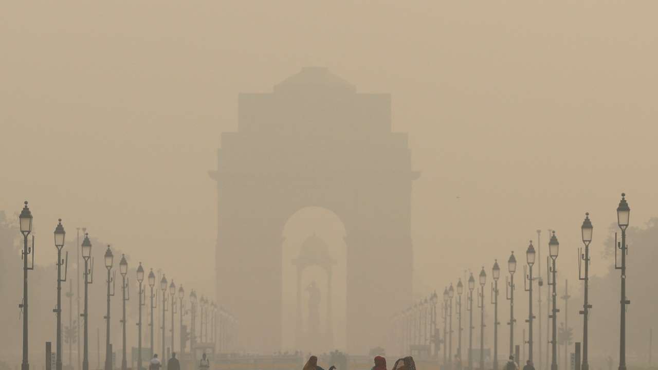 Women walk on a road near India Gate as the sky is enveloped with smog after Delhi's air quality worsened due to air pollution, in New Delhi