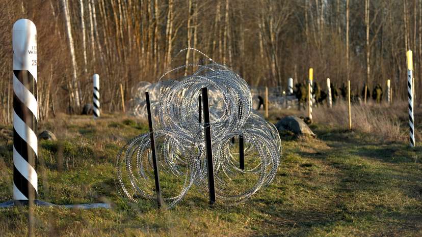 Estonian army reservists build a fence on a border with Russia near Meremae