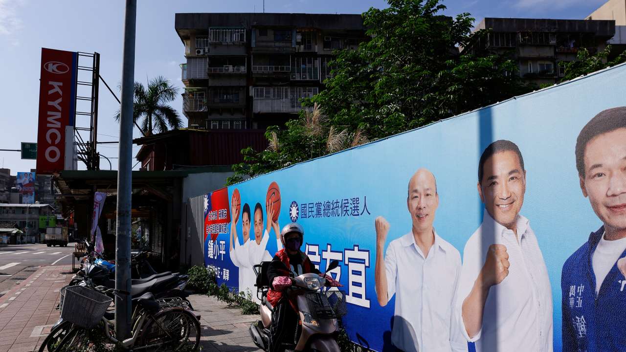 A person drives past a campaign ad for Hou Yu-ih, a candidate for Taiwan's presidency