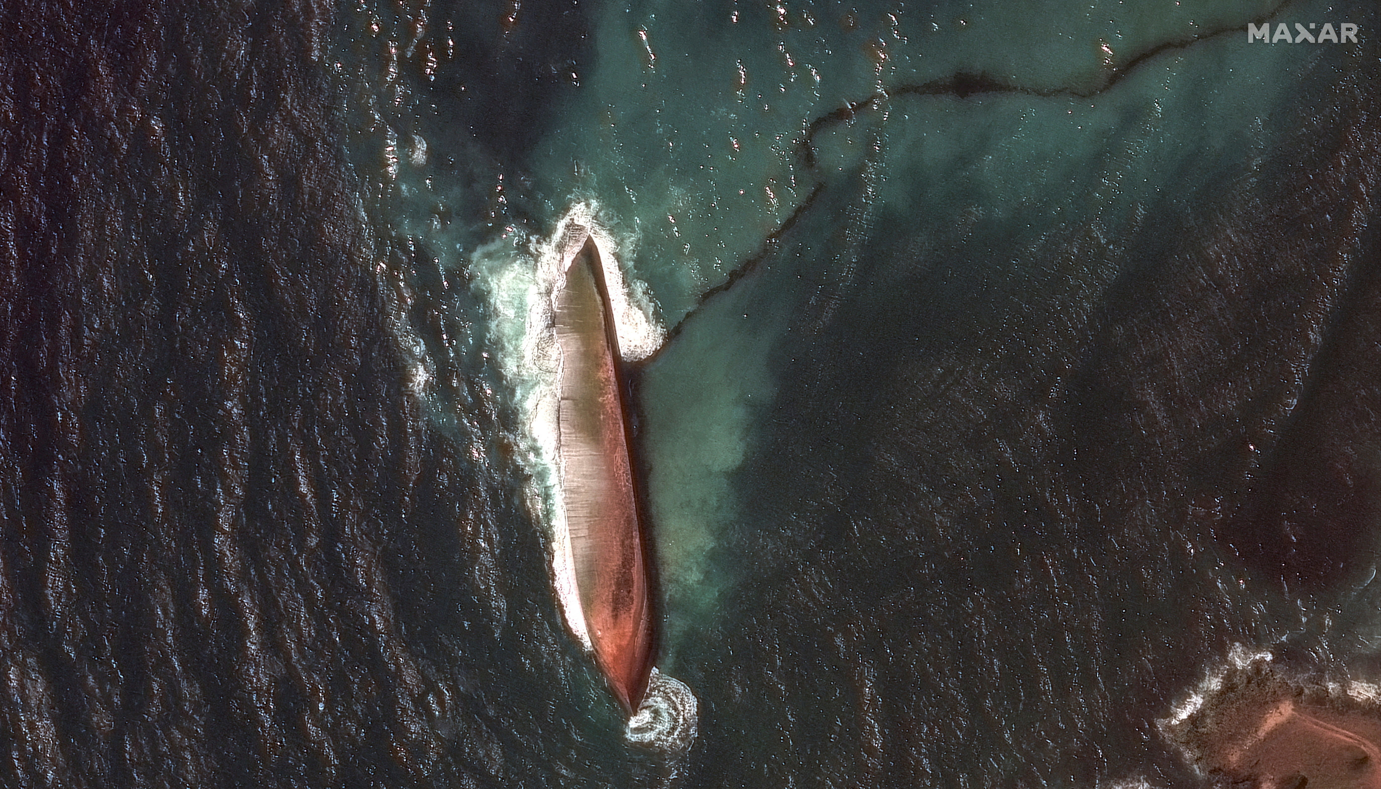 FILE PHOTO: A satellite image shows a close-up view of a capsized barge and an oil spill, off the shore of Tobago Island