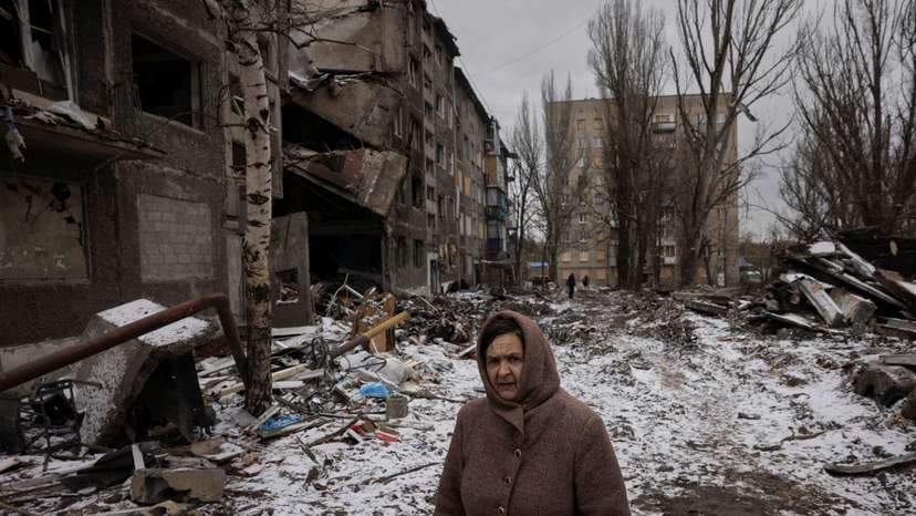 A woman walks past apartment blocks that were destroyed in a Russian missile strike in Selydove near Avdiivka
