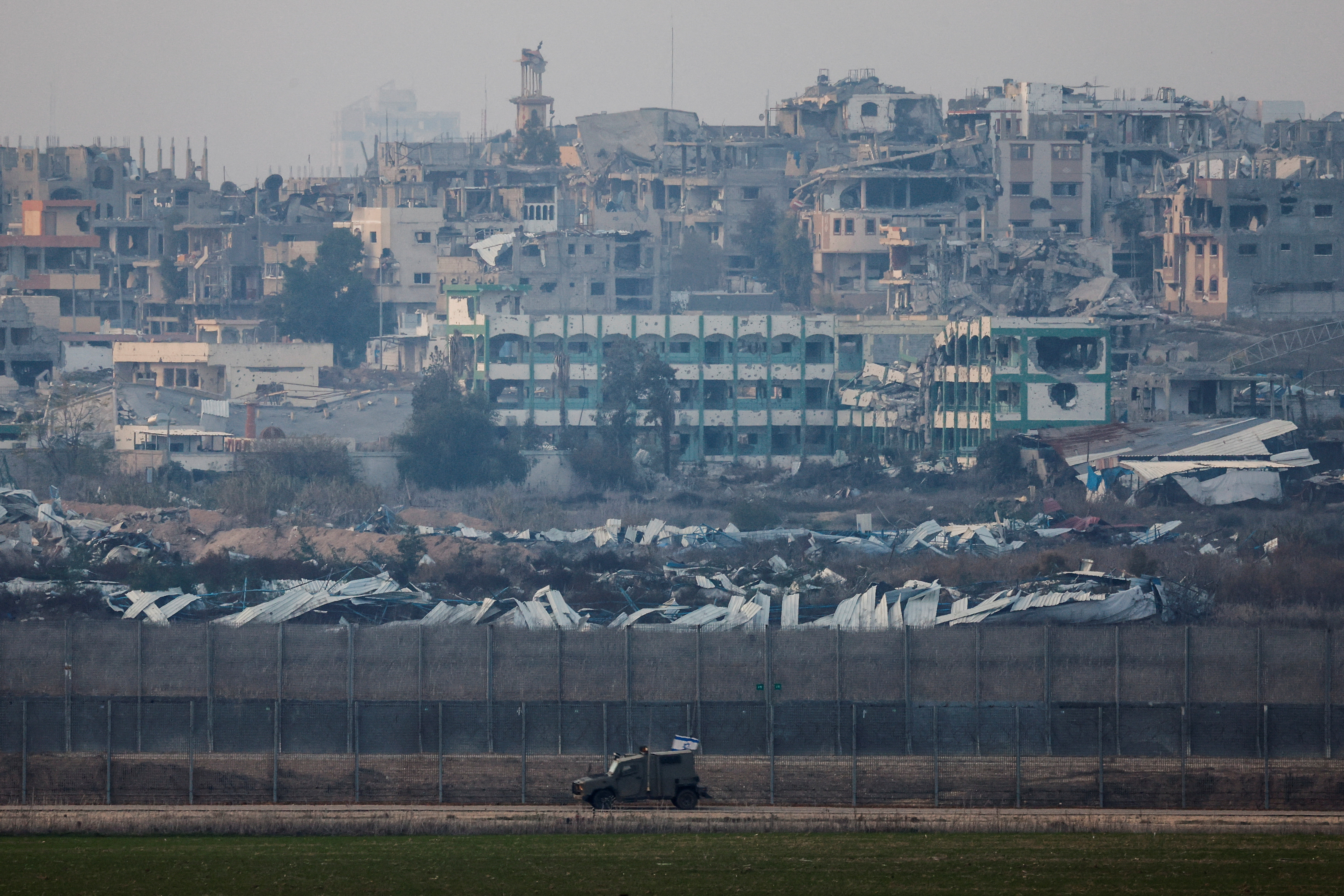 An Israeli military vehicles drives near the border with Gaza, as seen from the Israeli side of the border