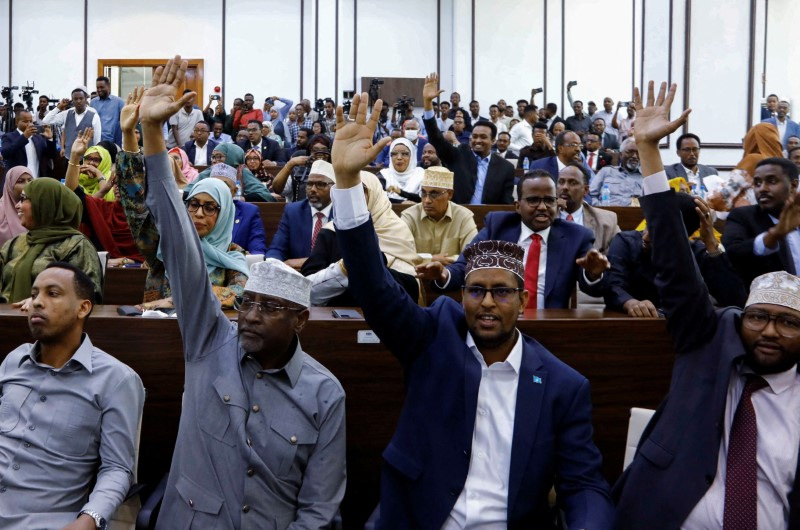 FILE PHOTO: Somali Members of Parliament raise their hands to vote on a resolution on the procedural rules for constitutional changes in Mogadishu