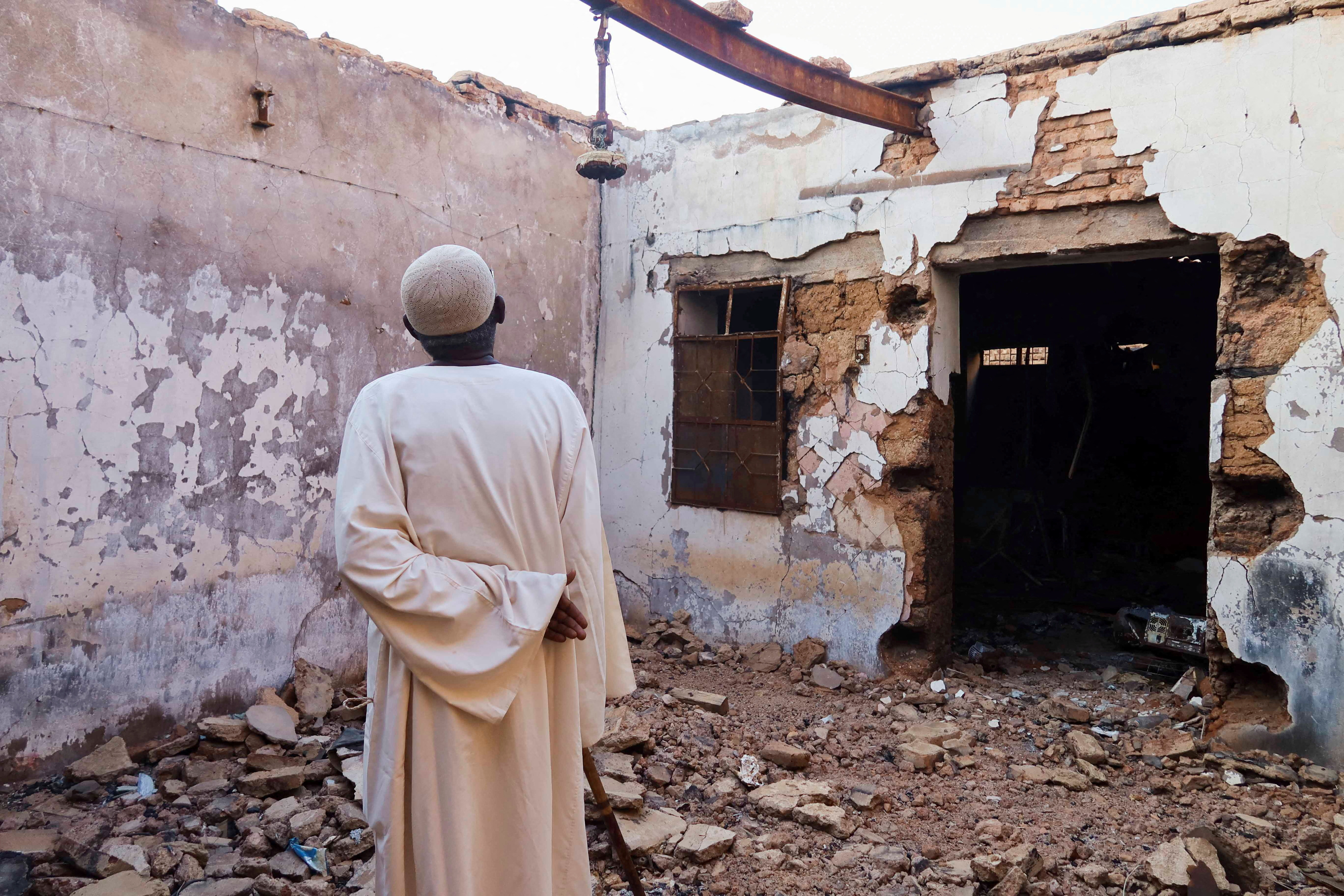 Hajj Ahmed, a resident of the Old-Omdurman neighbourhood, looks at his house after it was damaged by shells in Omdurman