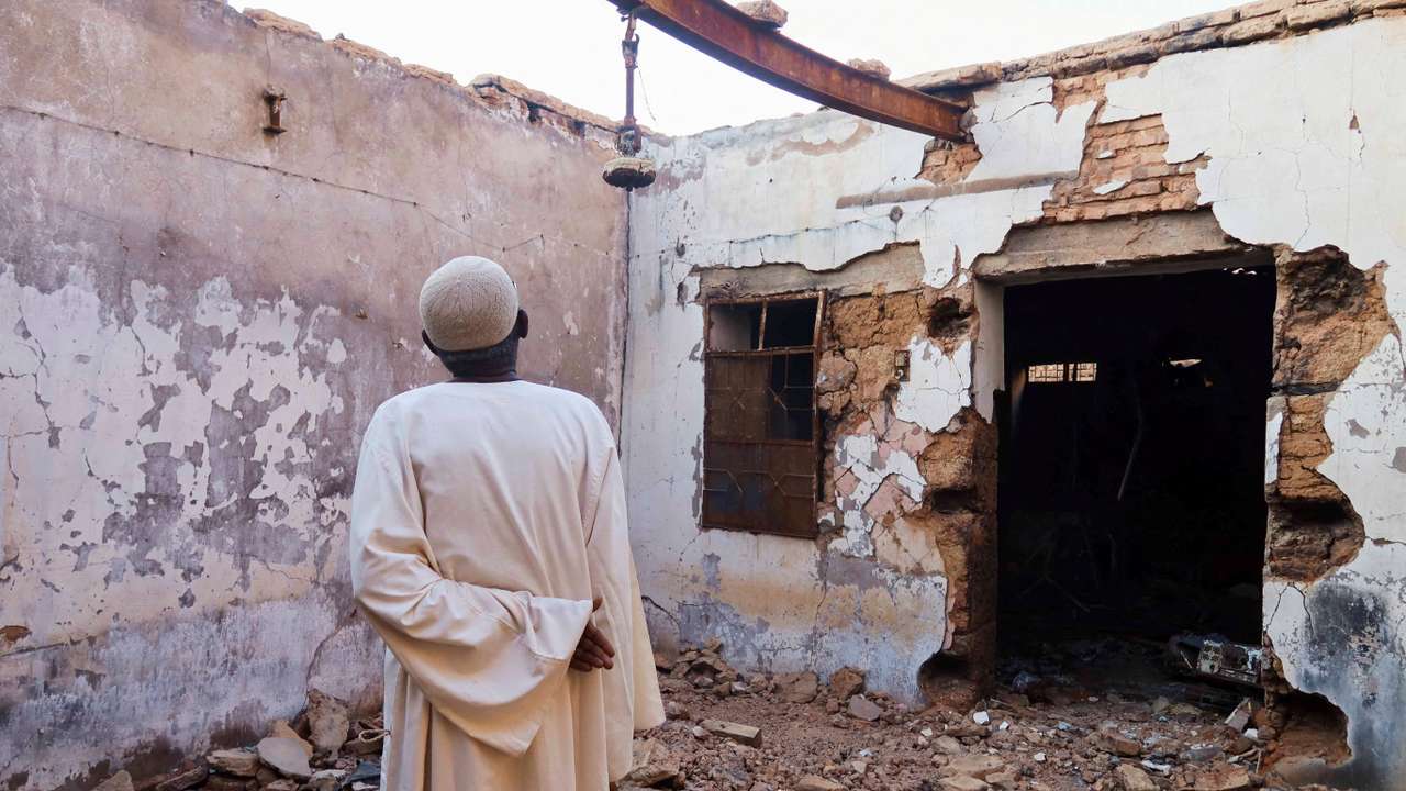 Hajj Ahmed, a resident of the Old-Omdurman neighbourhood, looks at his house after it was damaged by shells in Omdurman