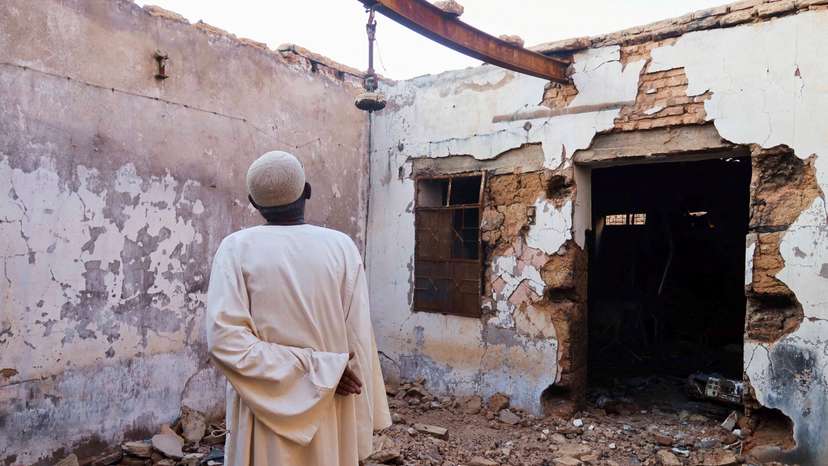Hajj Ahmed, a resident of the Old-Omdurman neighbourhood, looks at his house after it was damaged by shells in Omdurman