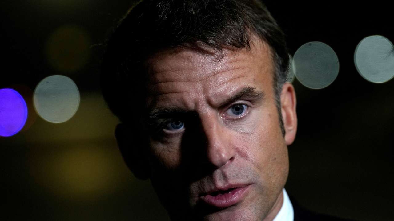 French President Emmanuel Macron talks to journalists on the tarmac of Cairo airport