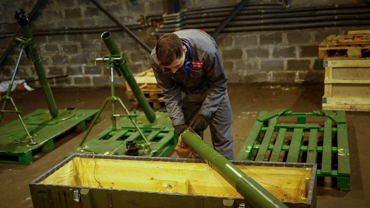 Employee prepares to place a mortar into a box at a production facility of the 'Ukrainian Armor' company in Ukraine