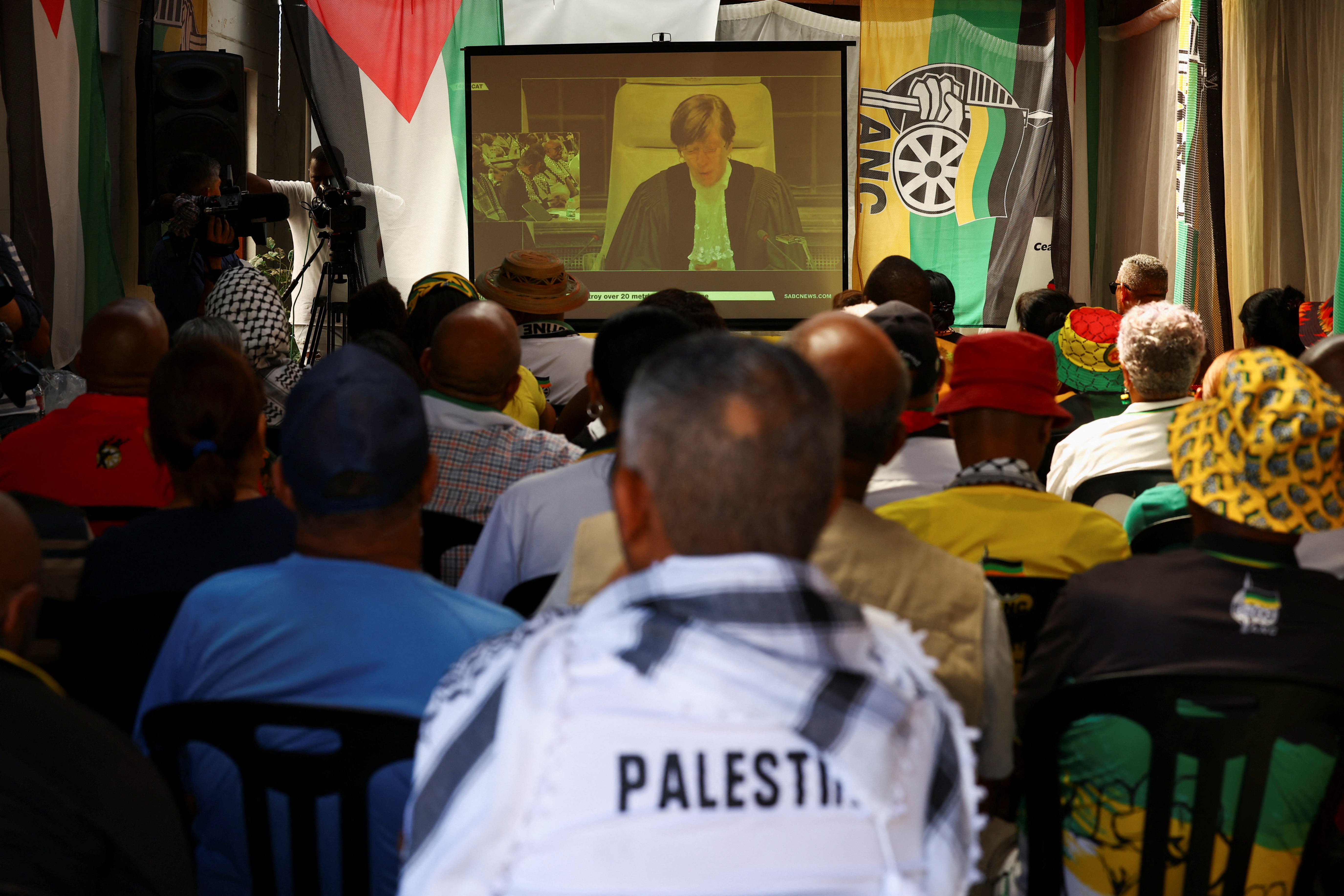Members of the African National Congress and members of the public watch the outcome of the World Court in Cape Town