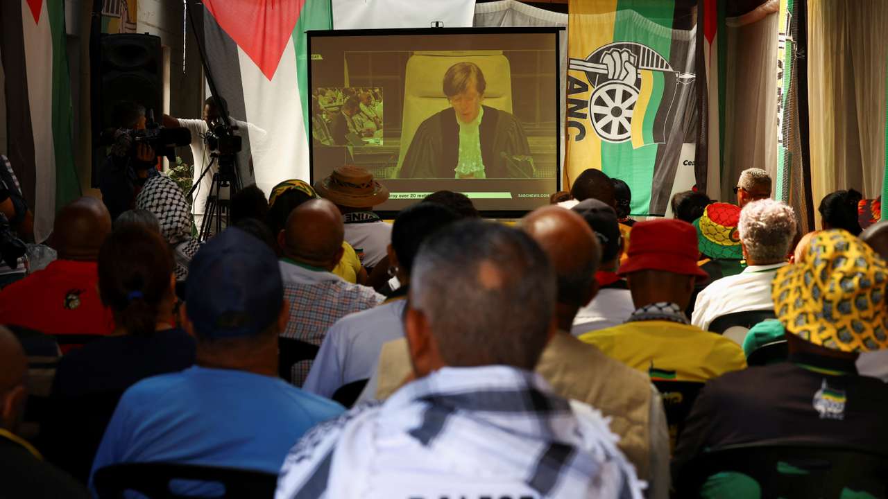 Members of the African National Congress and members of the public watch the outcome of the World Court in Cape Town