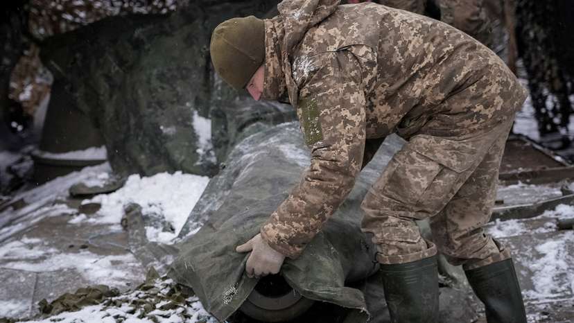 FILE PHOTO: A Ukrainian serviceman camouflages a self propelled howitzer at a front line near the town of Chasiv Yar
