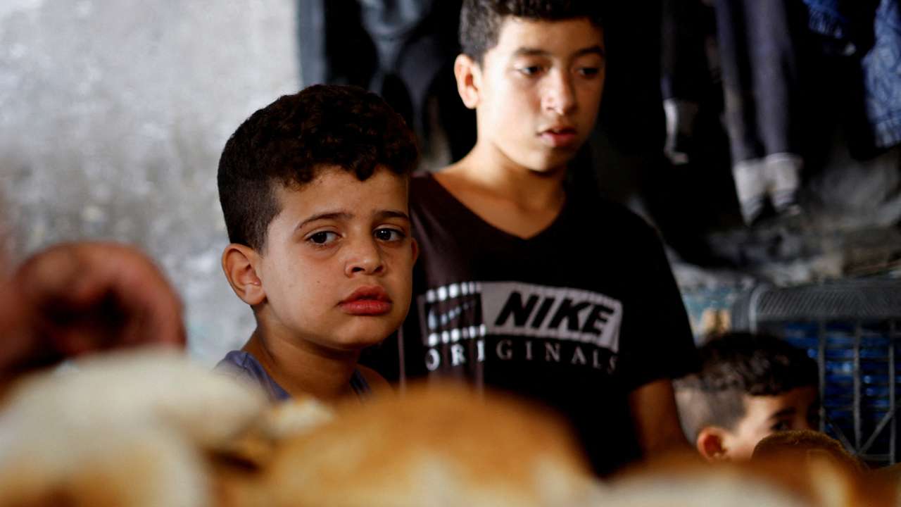 Palestinians wait to bake bread, as the conflict between Hamas and Israel continues