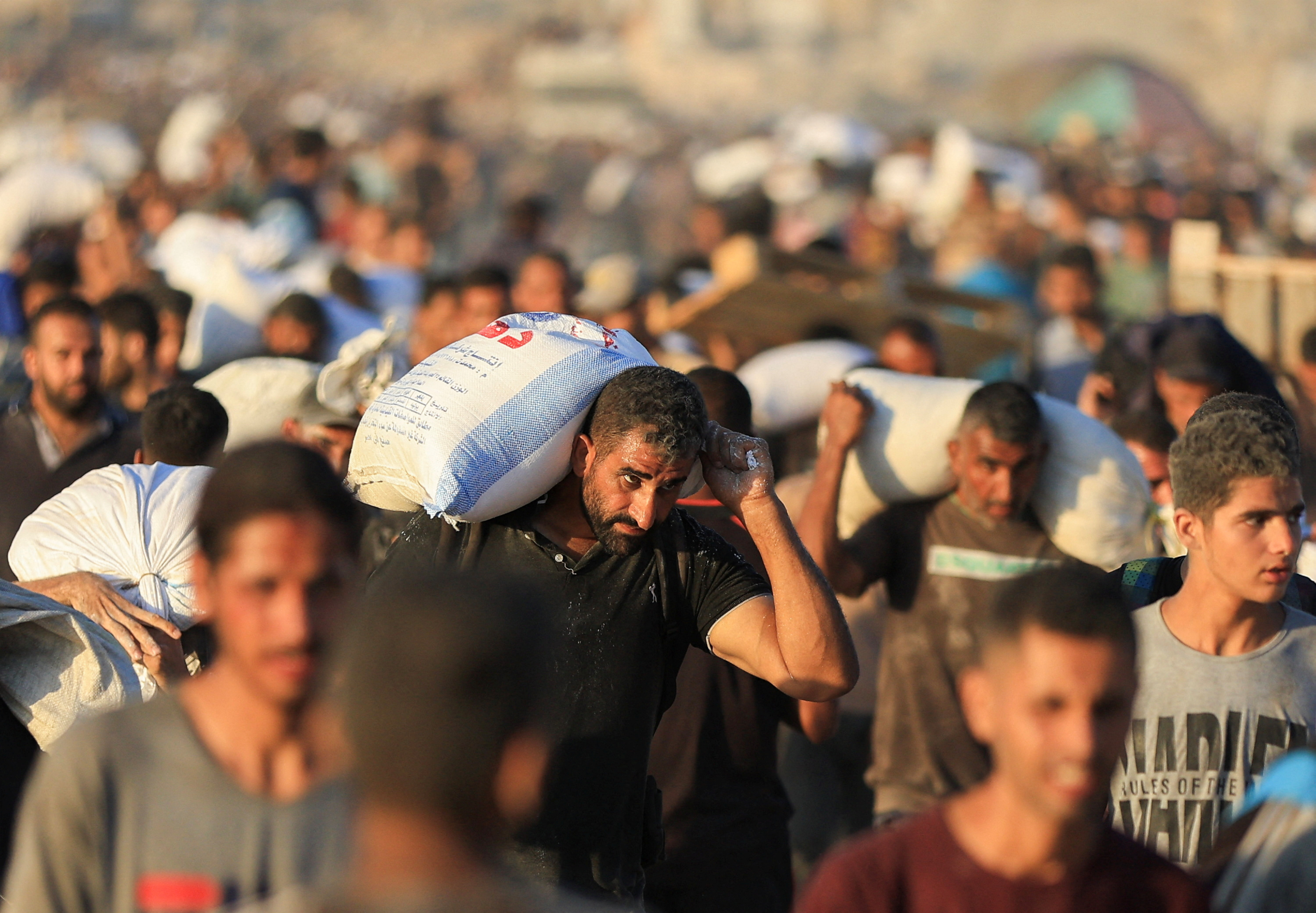 Palestinians carry aid supplies that entered Gaza through Israel, in Beit Lahia