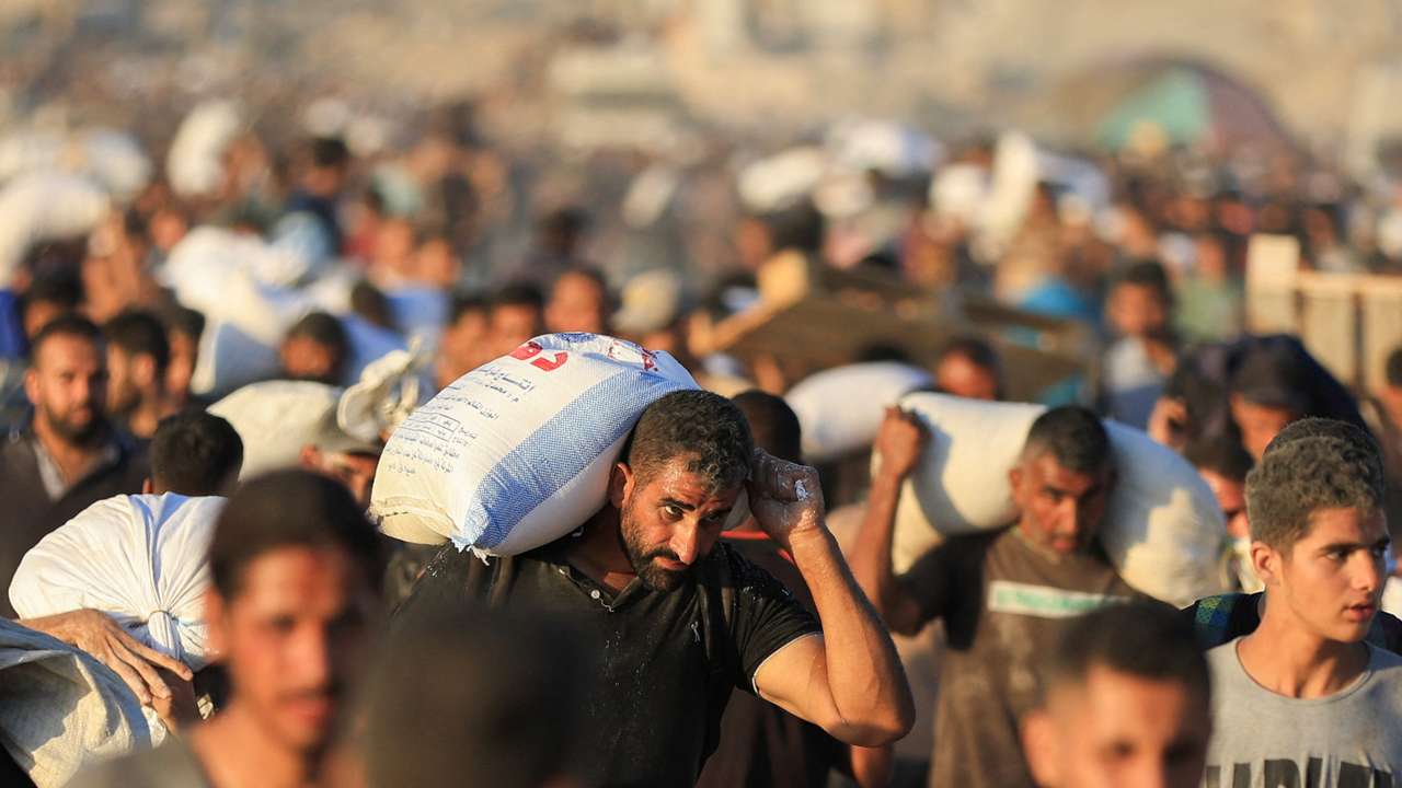 Palestinians carry aid supplies that entered Gaza through Israel, in Beit Lahia