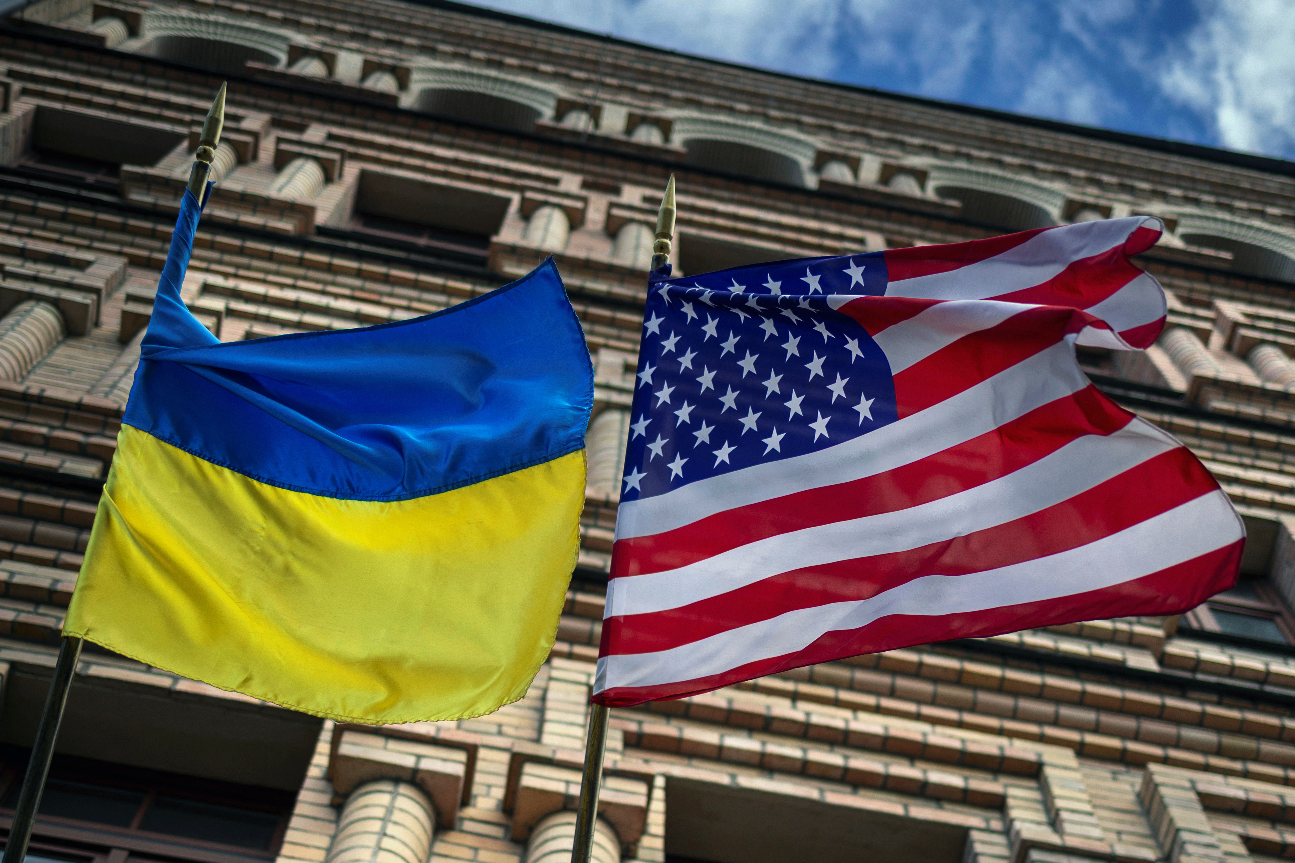 The Ukrainian and U.S. national flags fly outside a building in Kyiv
