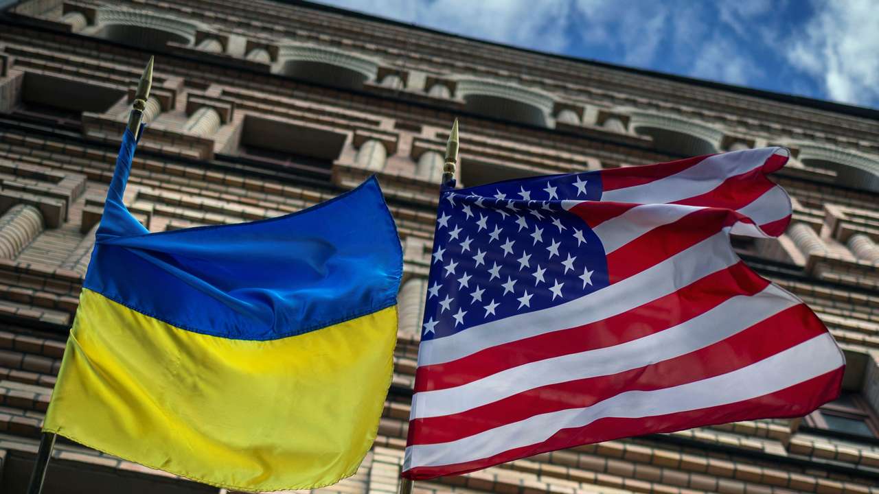 The Ukrainian and U.S. national flags fly outside a building in Kyiv