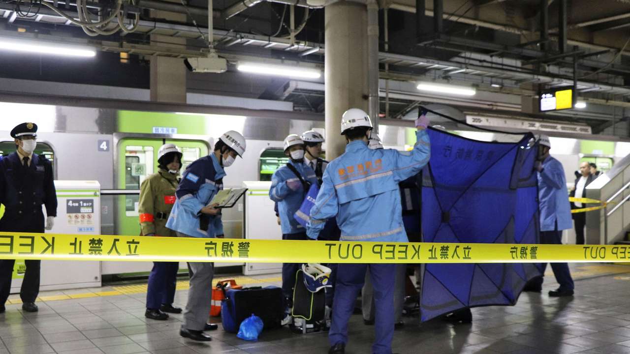 A person who believed to have been stabbed by a knife on the Yamanote loop train line is transported by ambulance members at JR Akihabara Station in Tokyo