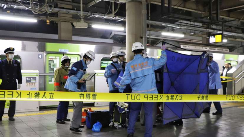 A person who believed to have been stabbed by a knife on the Yamanote loop train line is transported by ambulance members at JR Akihabara Station in Tokyo