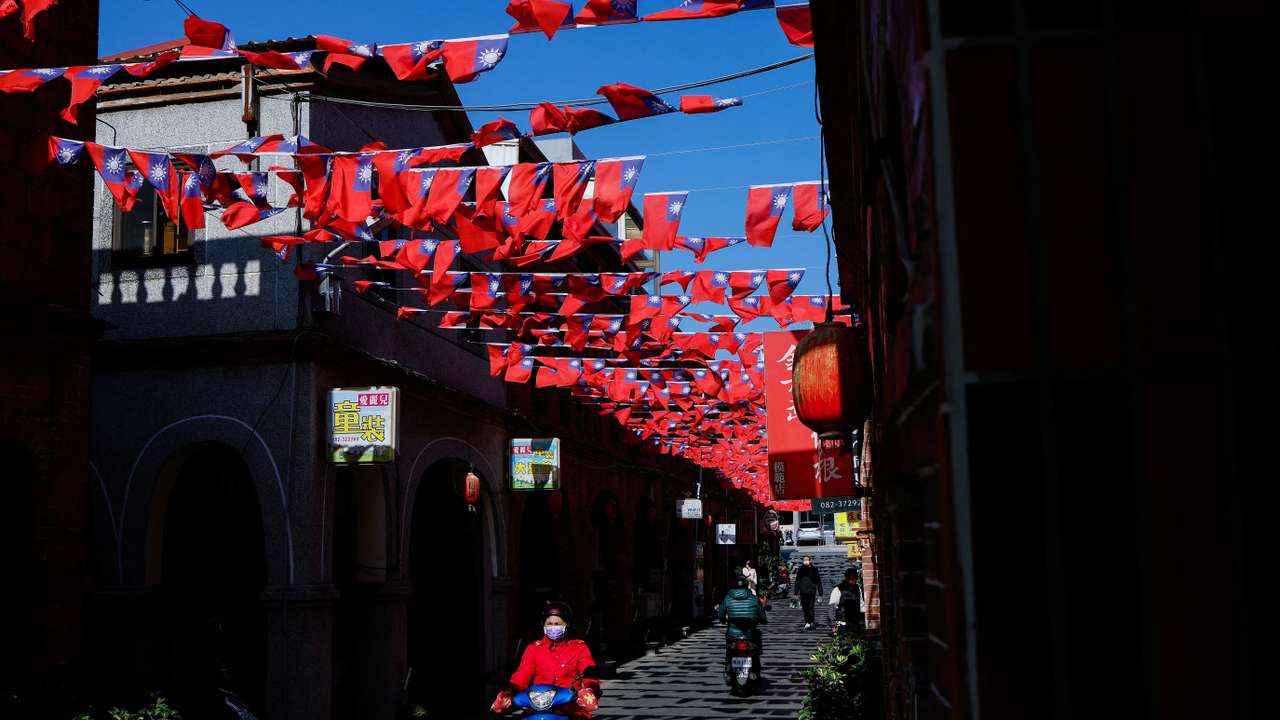 FILE PHOTO: People drive pass a street decorated with Taiwanese flags in Kinmen