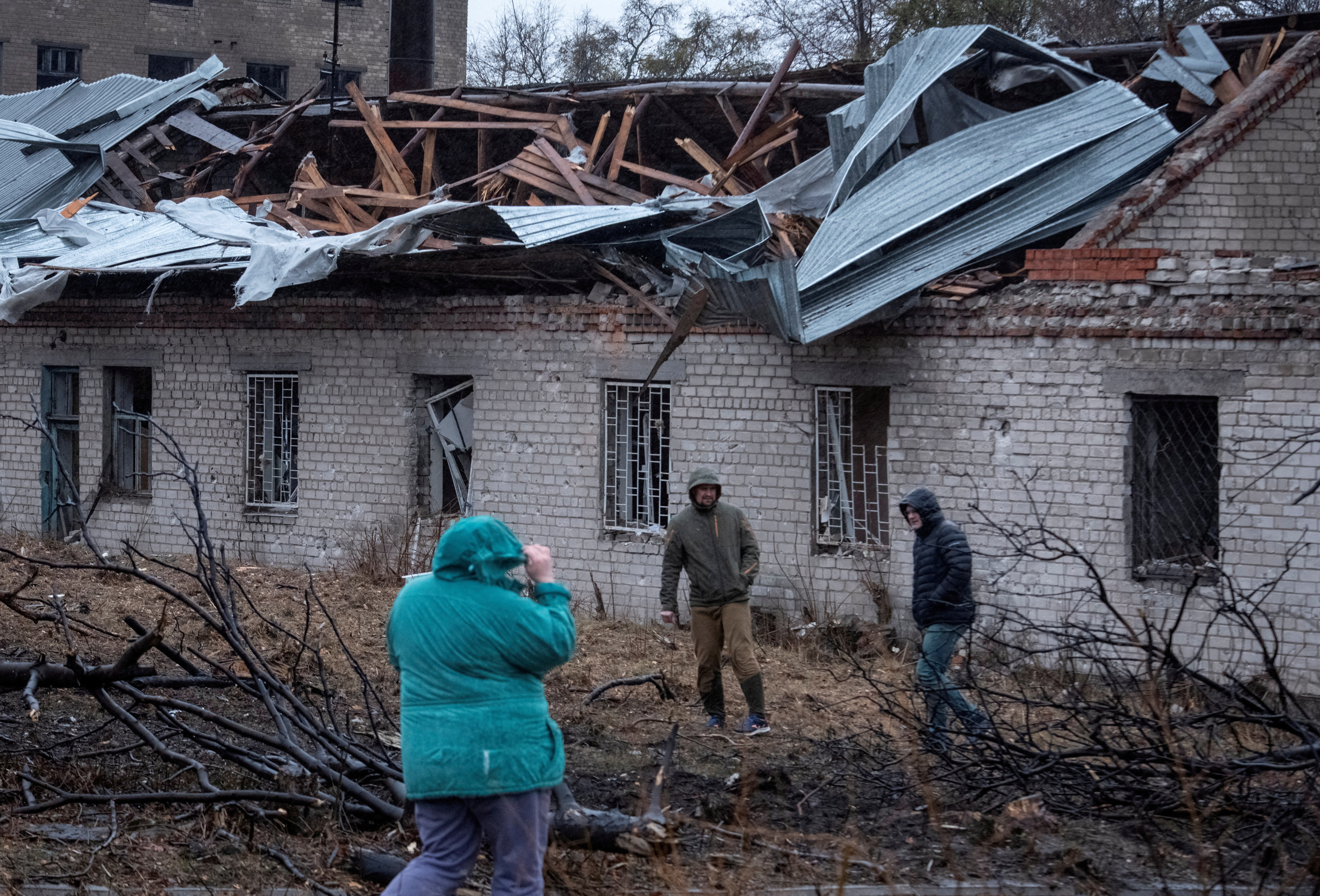 FILE PHOTO: Residents walk at a site of a Russian missile strike in Dnipro