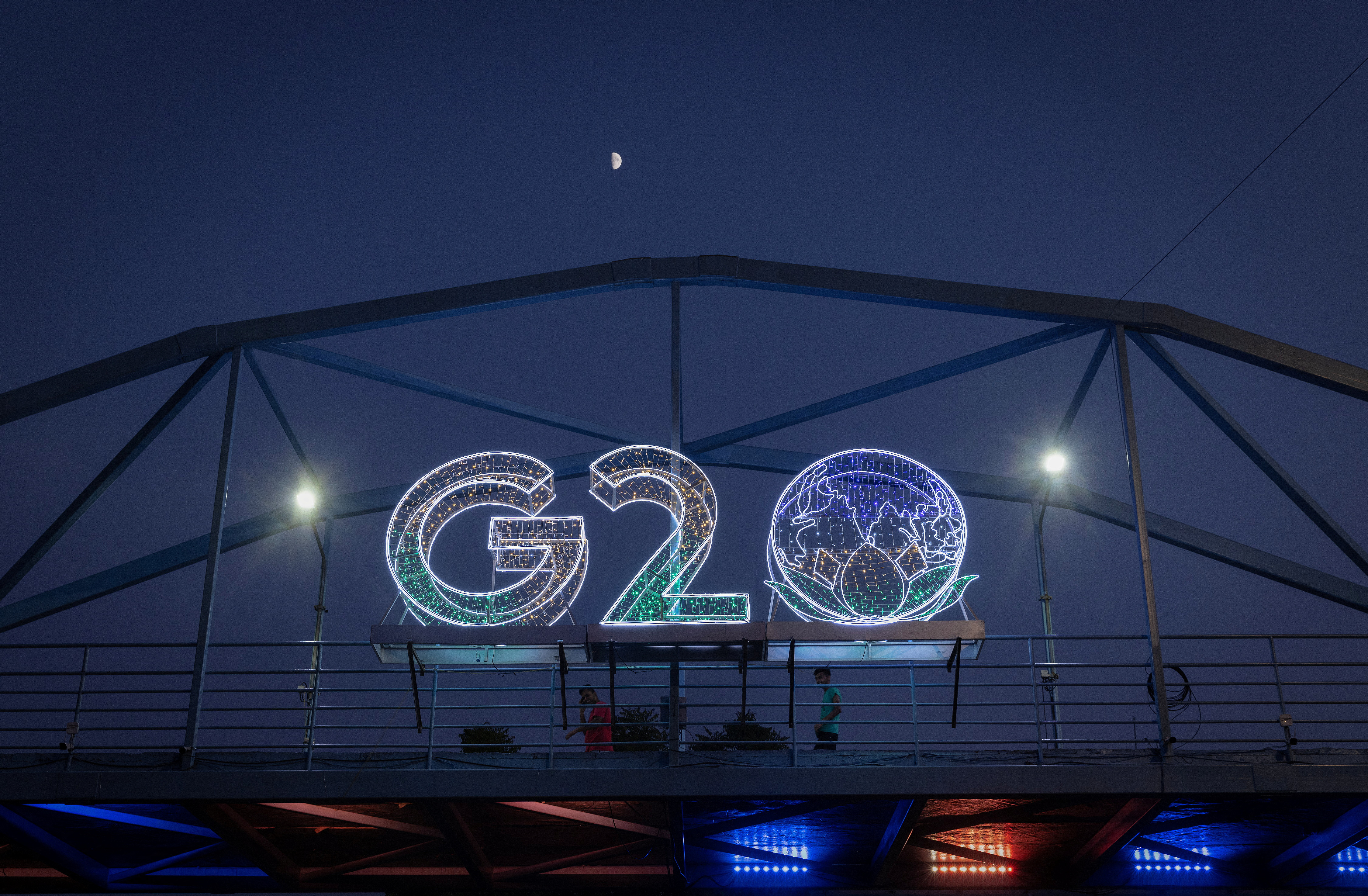 Moon is pictured above a G20 logo installed on a pedestrian bridge in front of the main venue of the summit in New Delhi