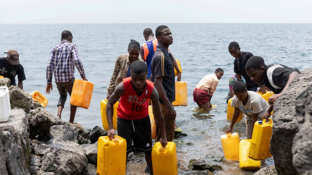 Civilians draw water from Lake Kivu after the town was taken by M23 rebels, in Goma,