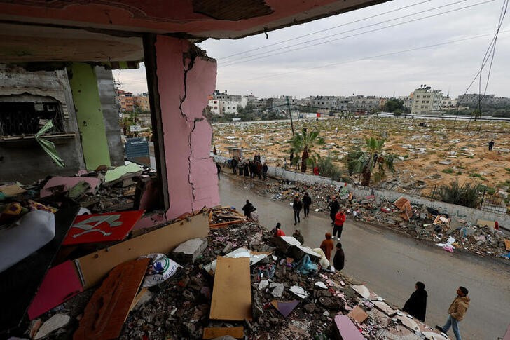 Palestinians inspect the site of an Israeli strike on a house in Rafah