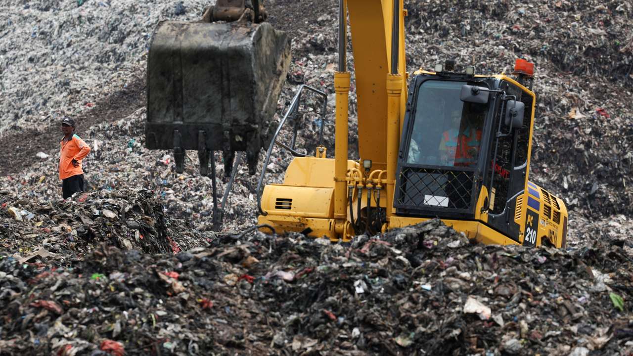 A worker stands amid garbage at the site of a collapse at the Bantar Gebang landfill, during a rescue operation in Bekasi