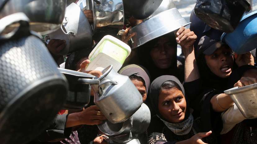 Palestinians wait to receive food from a charity kitchen, amid a hunger crisis, in Khan Younis