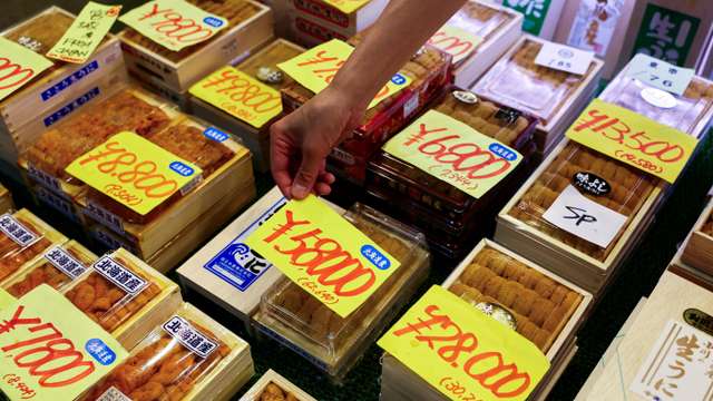 Employee at a wholesaler puts a price tag on a package of sea urchins from Hokkaido at Tsukiji Outer Market in Tokyo