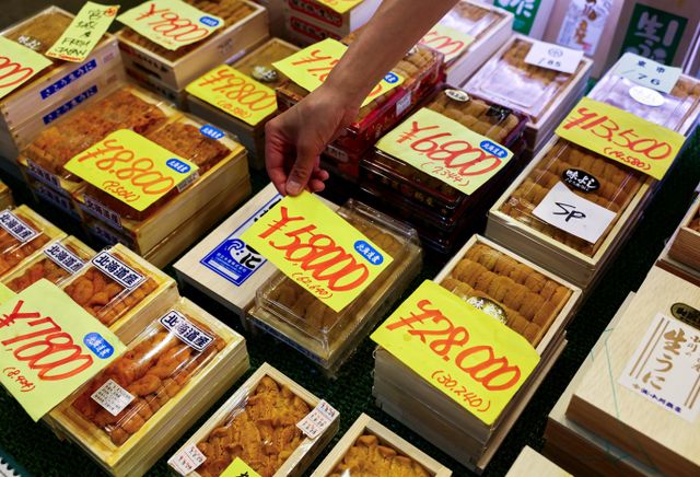 Employee at a wholesaler puts a price tag on a package of sea urchins from Hokkaido at Tsukiji Outer Market in Tokyo