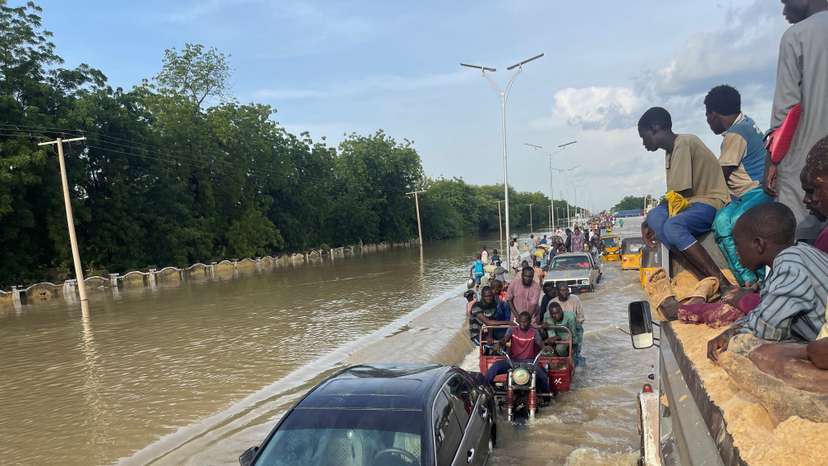 Residents leave the flooded areas with their belongings in Maiduguri