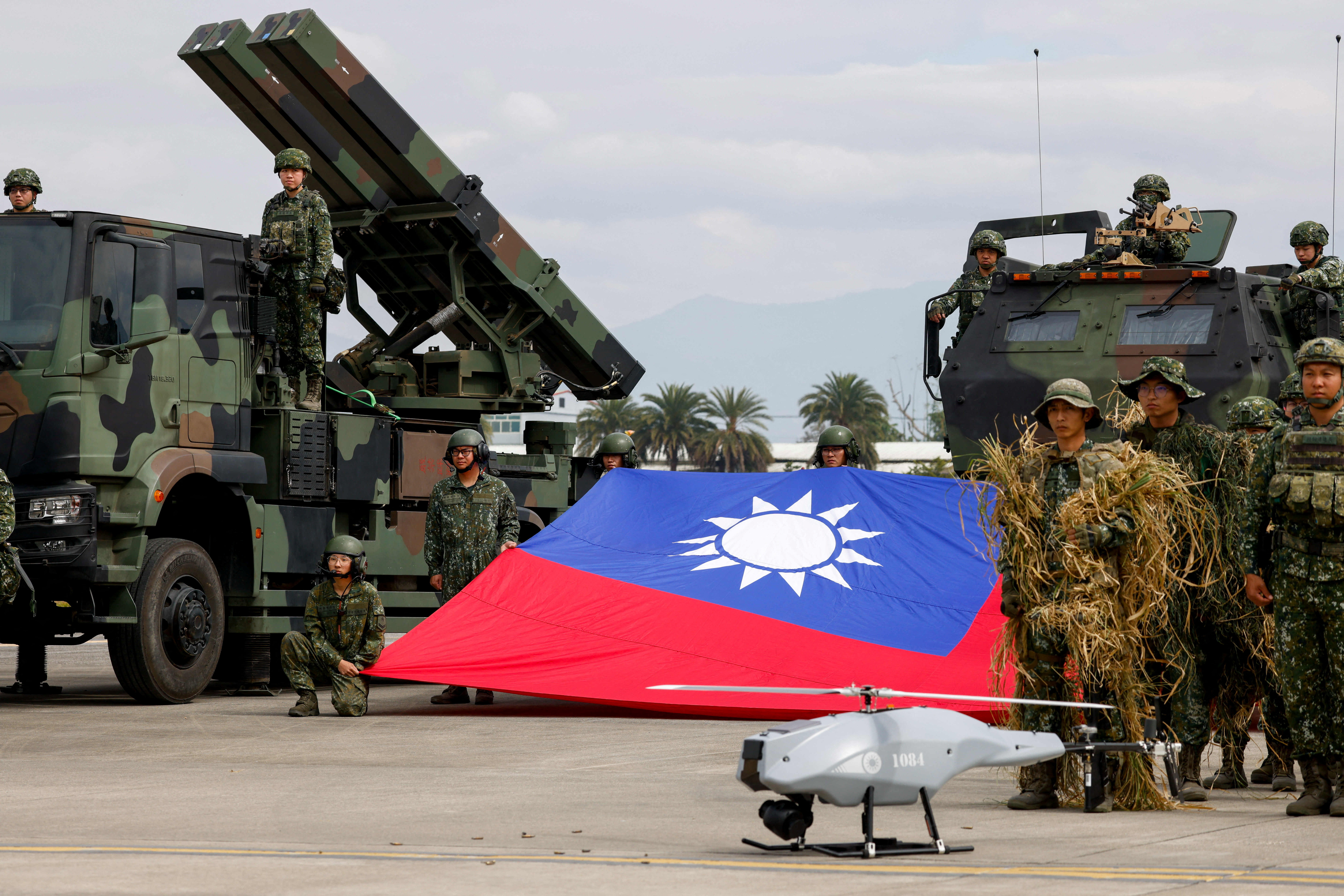 Taiwanese soldiers pose with a Taiwanese flag near a Sky Sword II surface-to-air missile launcher and a military UAV during an annual military exercise ahead of Lunar New Year in Taichung