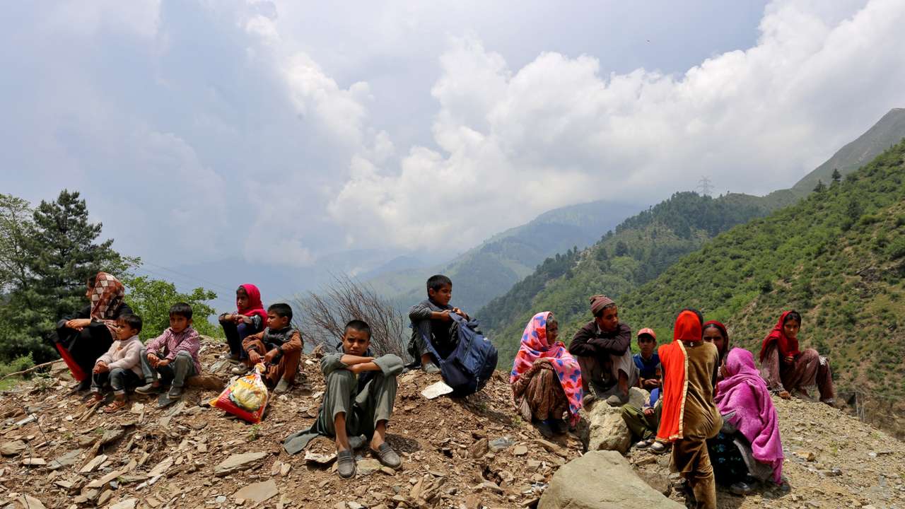 People wait as authorities stopped them returning to their villages until the areas are cleared of unexploded ordnance, in Gantamulla