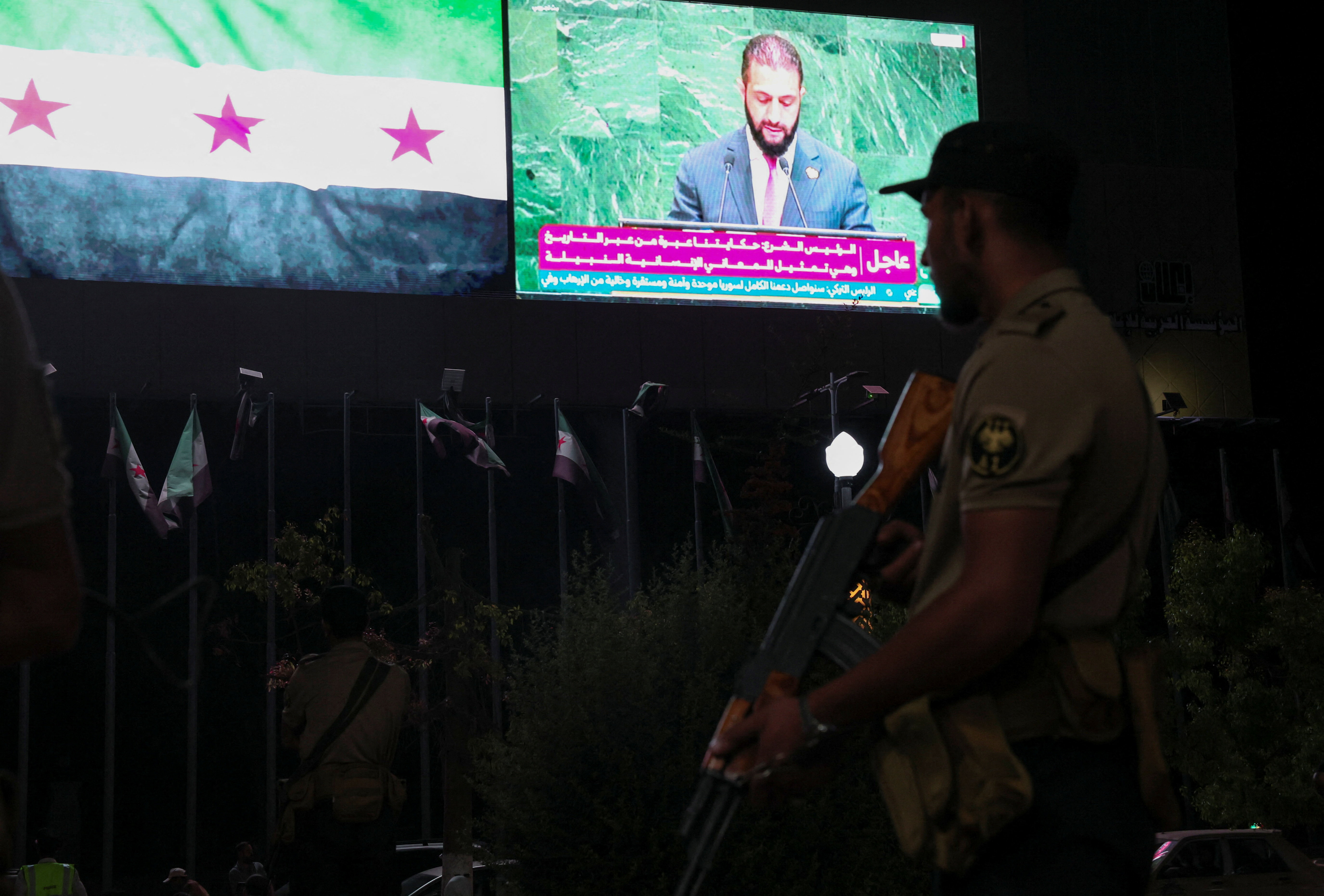 A member of the Syrian security forces stands during President Ahmad al-Sharaa's address at the United Nations General Assembly meeting, in Aleppo