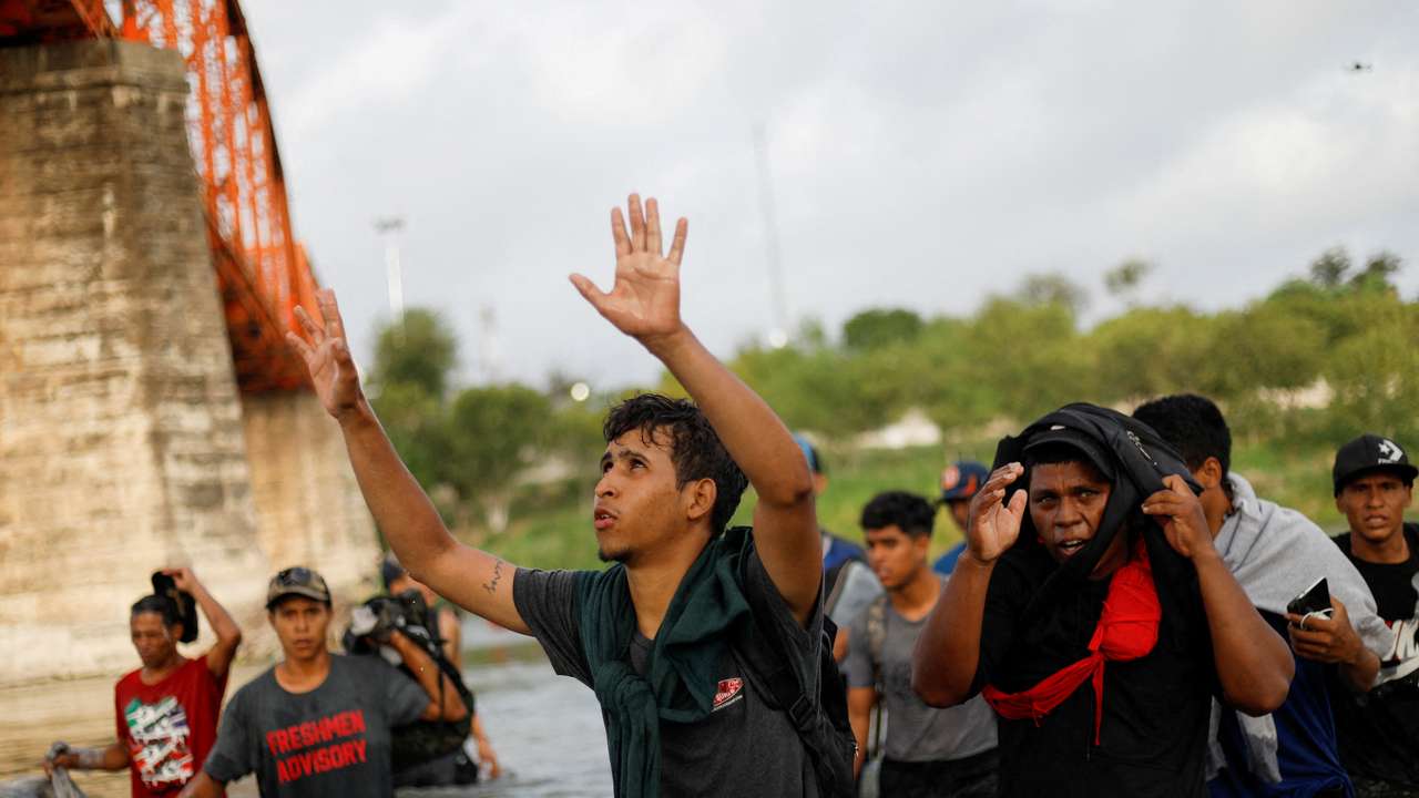 FILE PHOTO: Migrants walk through the Rio Grande river seeking asylum into the U.S., as seen from Piedras Negras