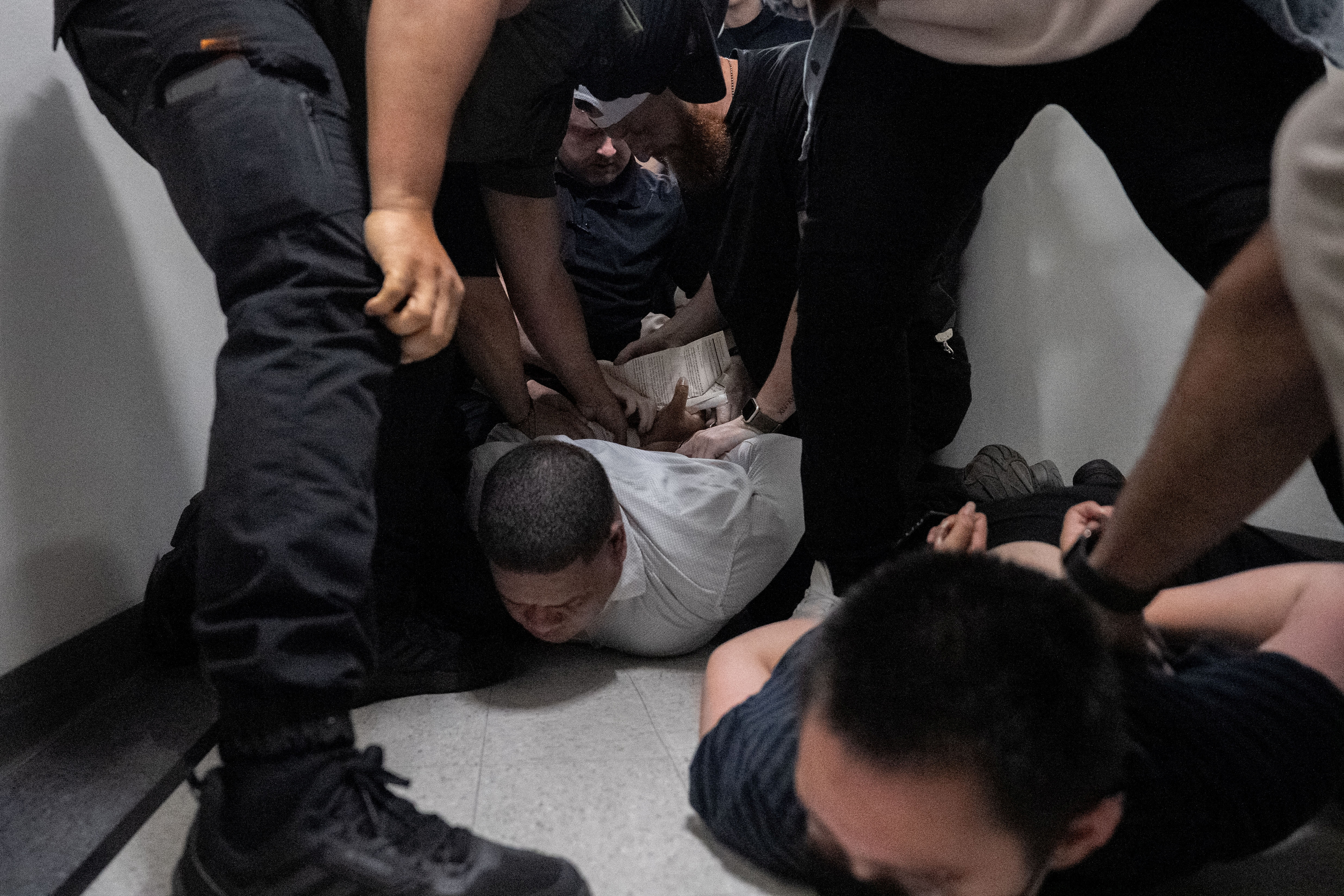 A migrant is detained by federal immigration officers at U.S. immigration court