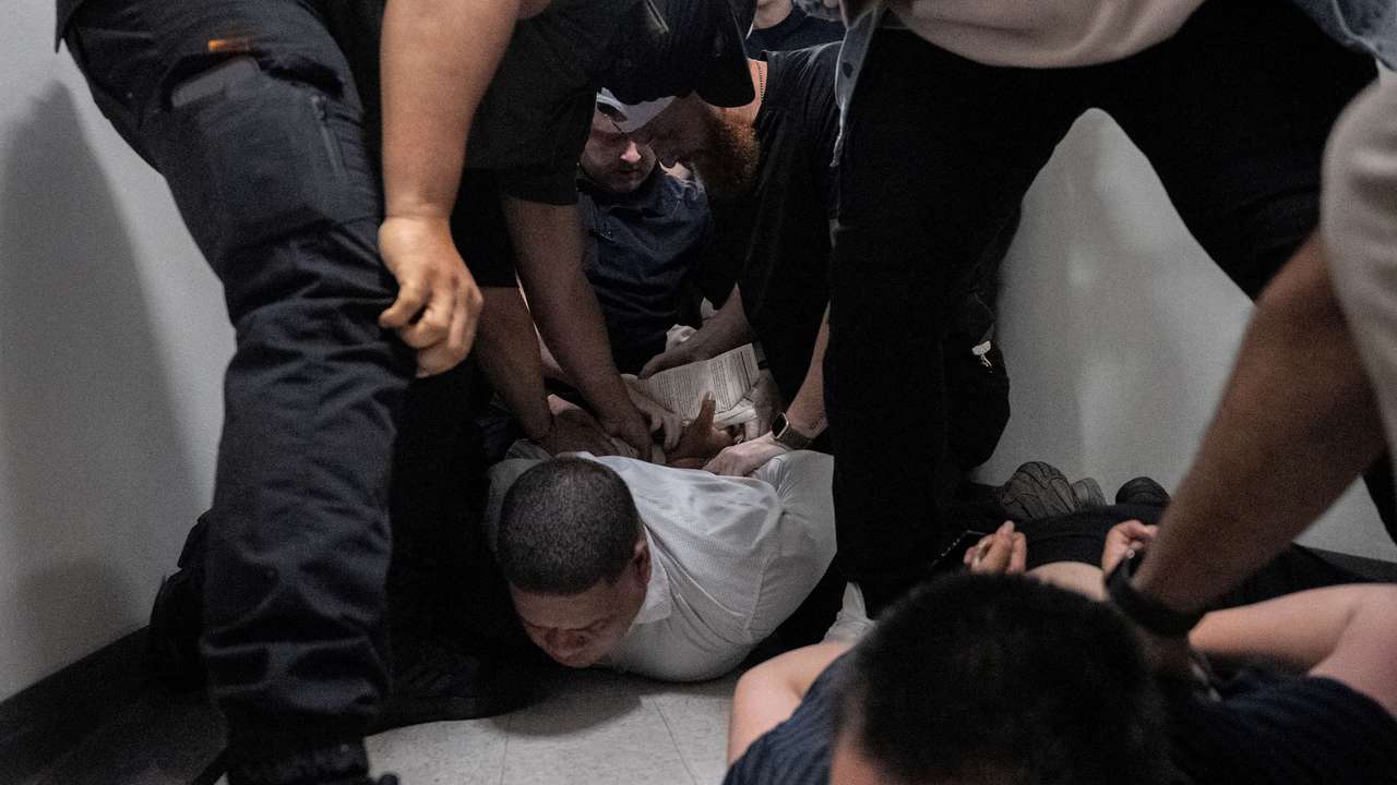 A migrant is detained by federal immigration officers at U.S. immigration court