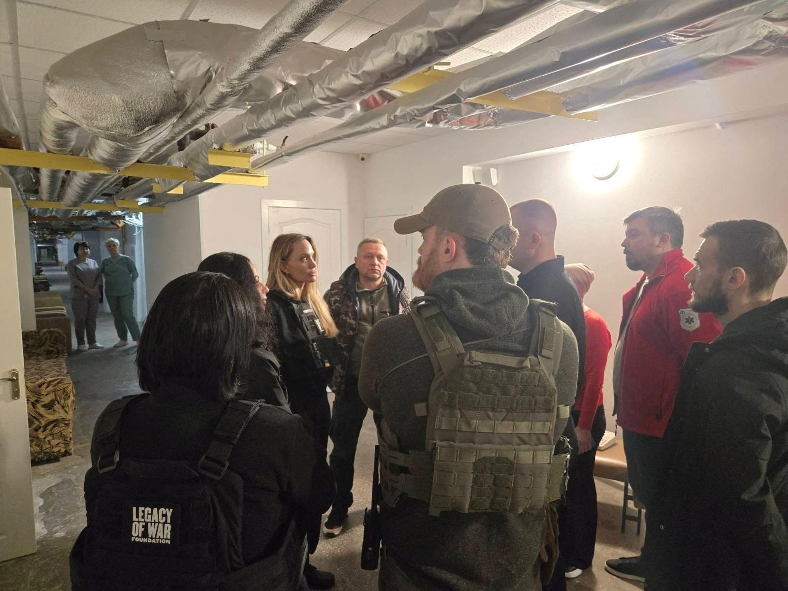 Angelina Jolie and others indoors with flak jackets, in Kherson