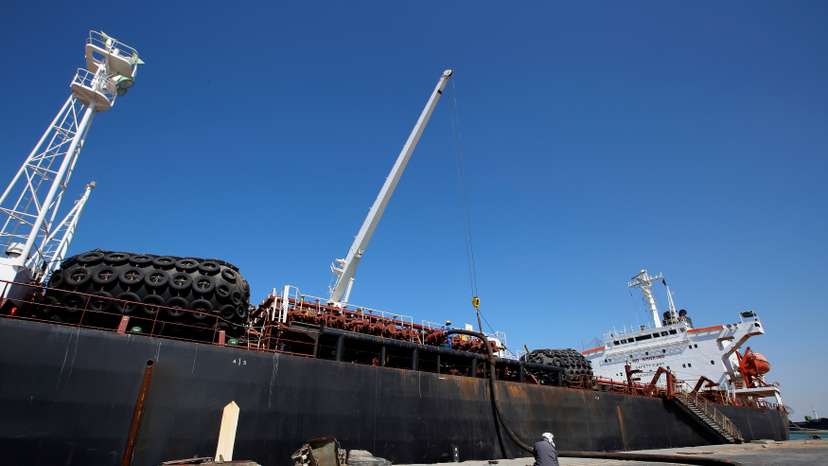 Worker sits next to fuel tanker Bahia Damas as it unloads its shipment of fuel at the Red Sea port of Hodeida, Yemen