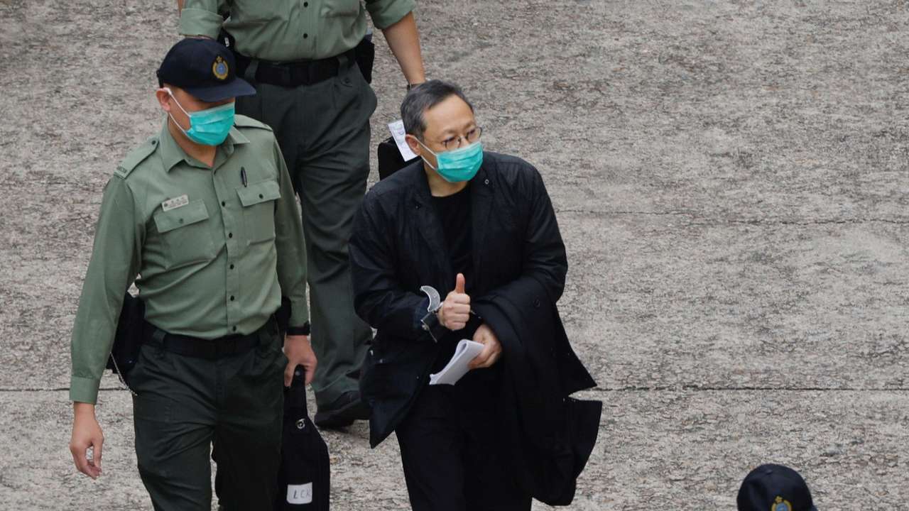 Pro-democracy activist Benny Tai flashes thumbs up as he walks to a prison van to head to court, over the national security law charge, in the early morning, in Hong Kong
