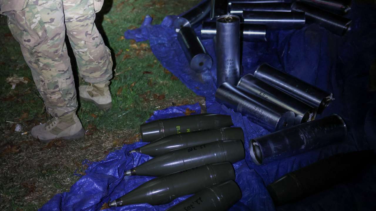 Ukrainian serviceman stands next to artillery shells at his position in a front line in Southern Ukraine