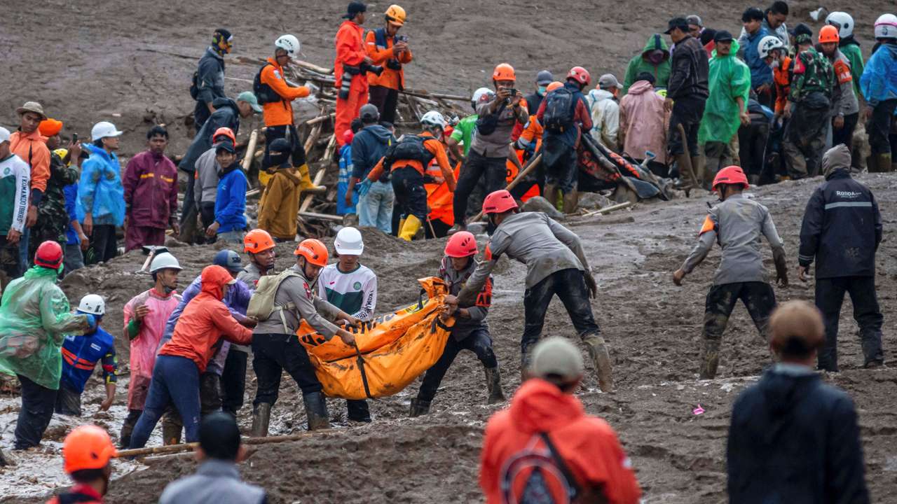 Indonesian rescue members carry a body bag containing the remains of a victim from the site of a landslide after it hit Pasirlangu village, West Bandung