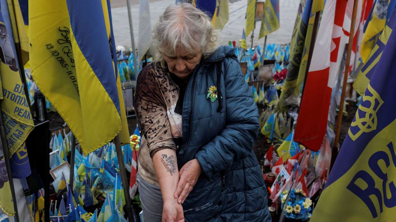 Natalia Lipei shows a tattoo with the call sign of her killed son and the emblem of a brigade where he served, as she visits a makeshift memorial to fallen Ukrainian defenders at the Independence Square in Kyiv
