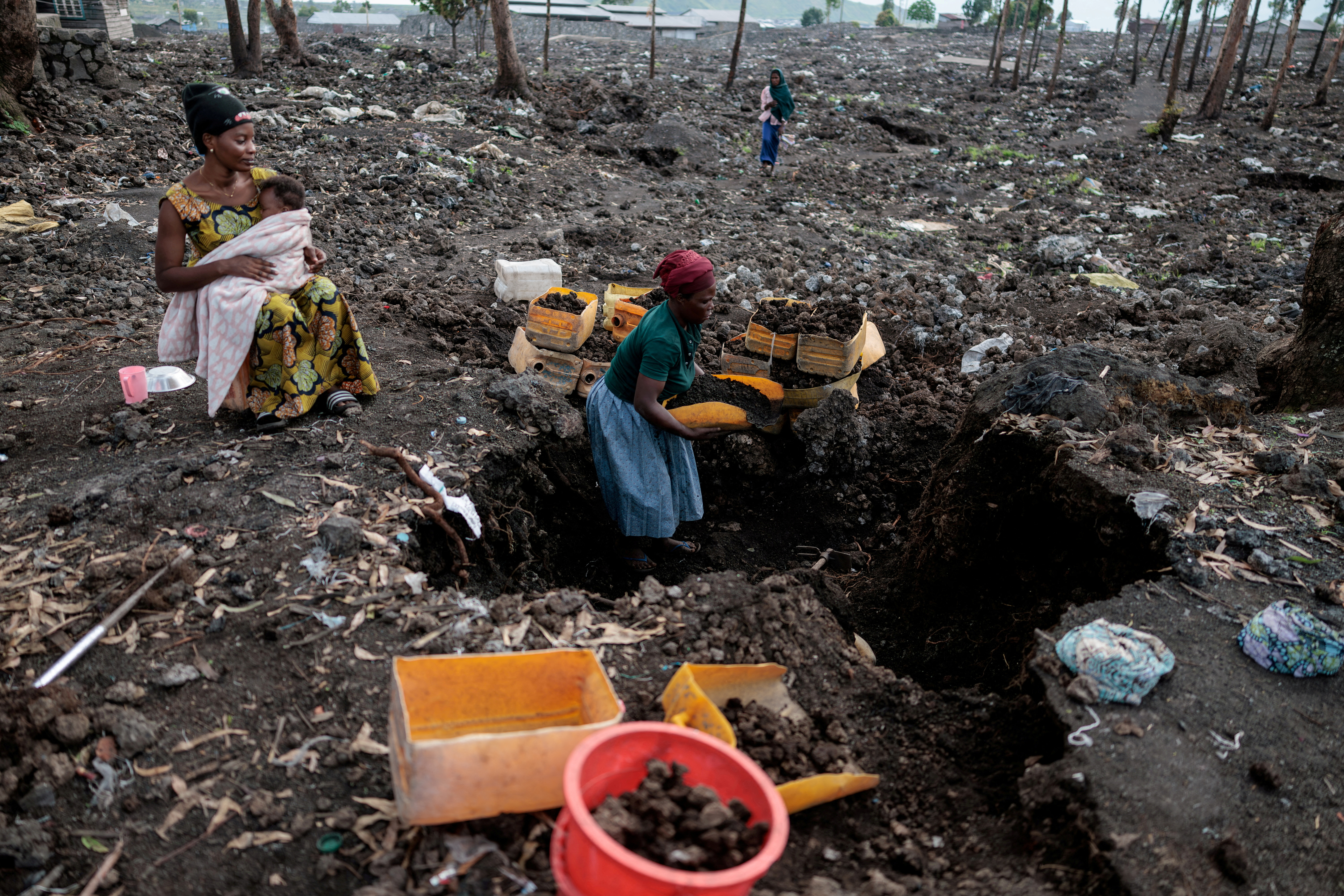 FILE PHOTO: Kahindo, an internally displaced woman, gathers volcanic gravel to sell at Lushagala IDP’s camp near Goma